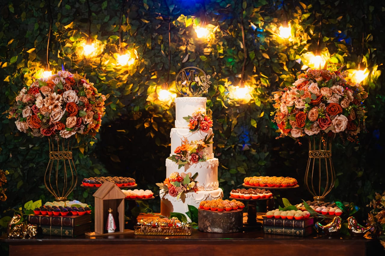 Mesa de bolo decorada com flores e iluminação aconchegante